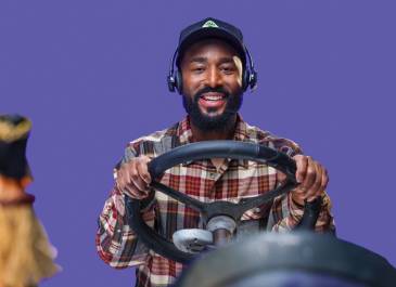 Man sitting behind steering wheel with hula girl in the foreground