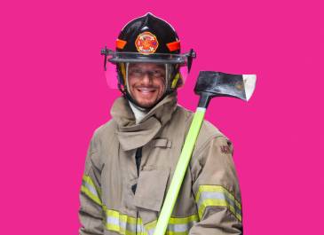 Man wearing firefighting helmet and jacket holding an ax
