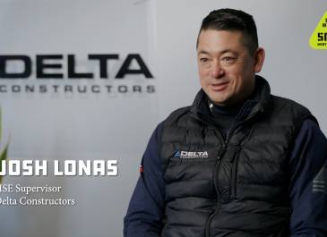 Man in Delta Constructors vest sitting with Delta Constructors name on the background and the Get Home Safe logo in the upper right hand corner