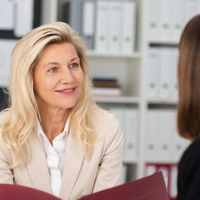 Two women seated reviewing drug free policy.