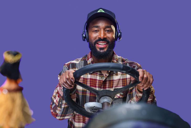 Man sitting behind steering wheel with hula girl in the foreground
